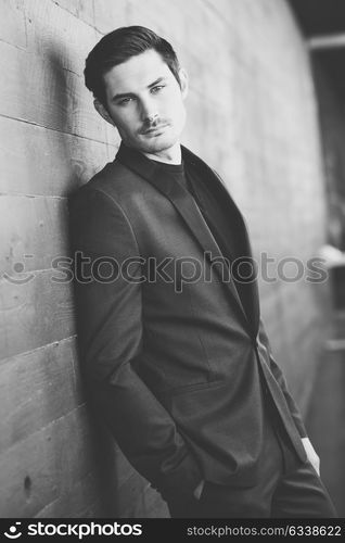 Portrait of an attractive young businessman outdoors, wearing modern suit.