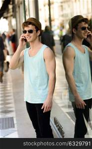 Portrait of an attractive young man wearing hat talking on the mobile phone