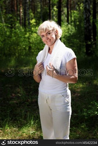 Portrait of an elderly woman in sportswear with a towel. The symbol of healthy lifestyles.
