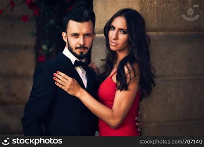 Portrait of an elegant couple in a official evening wear on the background of a classic architecture