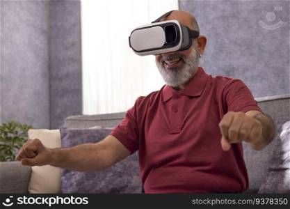 Portrait of an excited senior man experiencing virtual reality eyeglasses headset at home in the living room