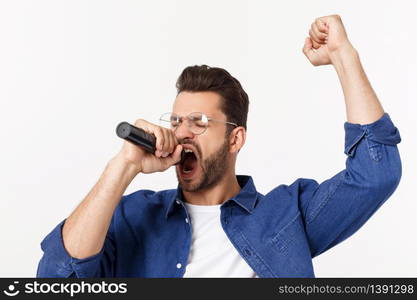 Portrait of an excited young man in t-shirt isolated over gray backgound, singing. Portrait of an excited young man in t-shirt isolated over gray backgound, singing.