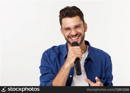 Portrait of an excited young man in t-shirt isolated over gray backgound, singing. Portrait of an excited young man in t-shirt isolated over gray backgound, singing.