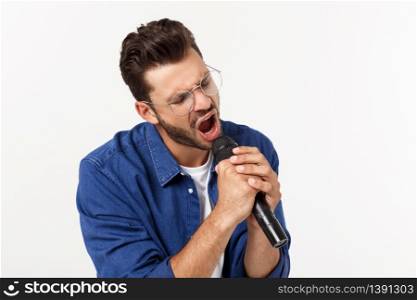 Portrait of an excited young man in t-shirt isolated over gray backgound, singing. Portrait of an excited young man in t-shirt isolated over gray backgound, singing.