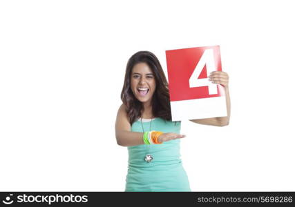Portrait of an excited young woman holding a signaling a four over white background