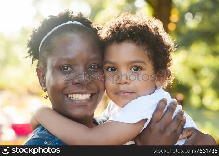 Portrait of an happy african mother and baby embracing and looking at the camera.