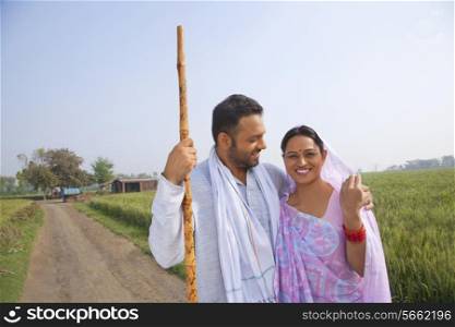 Portrait of an Indian couple smiling with field in background