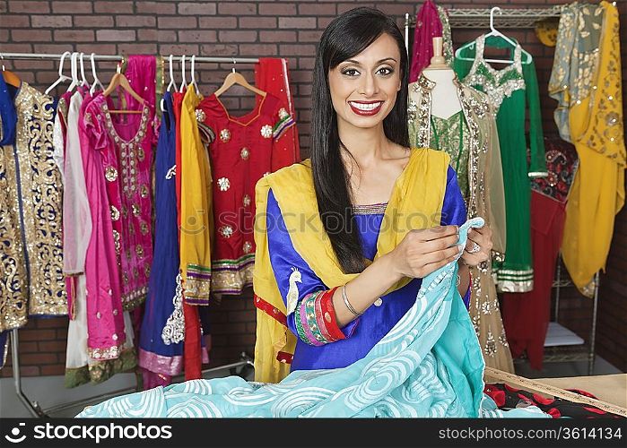 Portrait of an Indian female dressmaker working at design studio