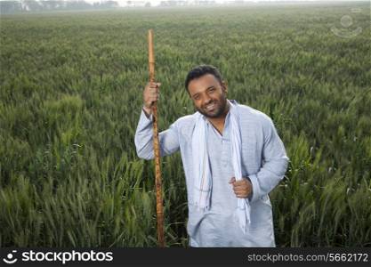 Portrait of an Indian man holding a stick
