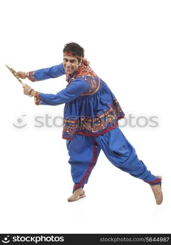 Portrait of an Indian man performing Dandiya Raas over white background