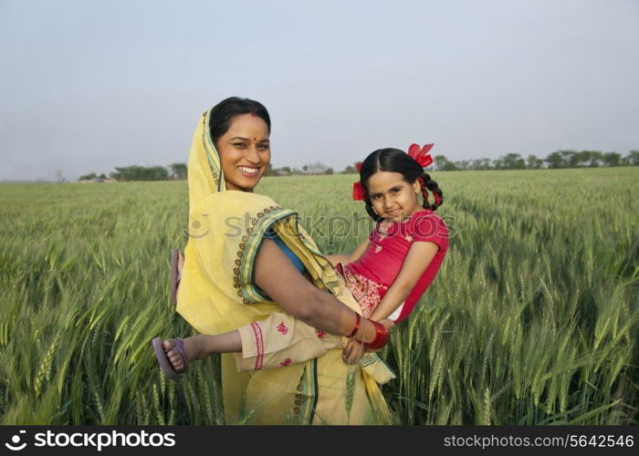 Portrait of an Indian mother playing with her daughter in the field