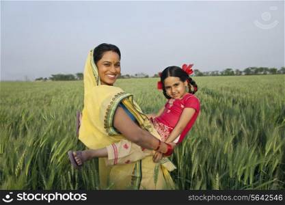 Portrait of an Indian mother playing with her daughter in the field