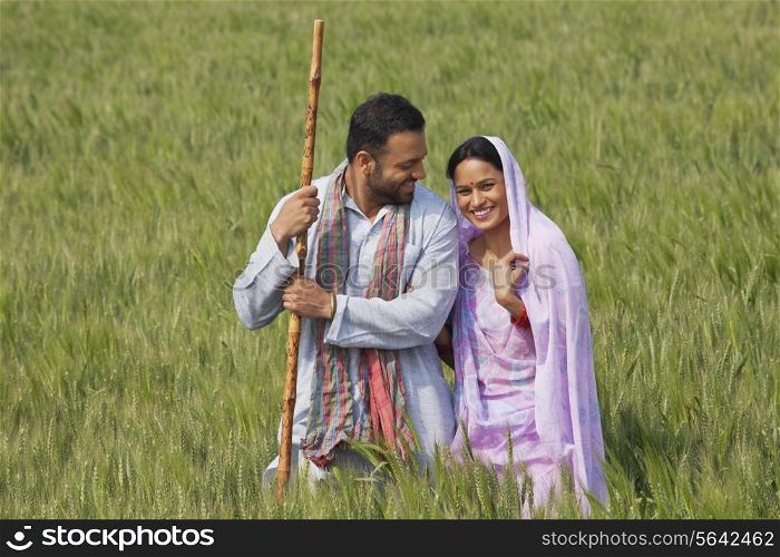 Portrait of an Indian woman standing with her husband in wheat field