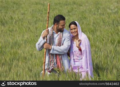 Portrait of an Indian woman standing with her husband in wheat field