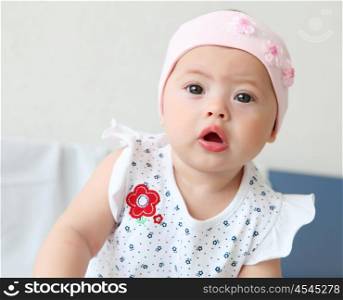 portrait of an infant baby girl wearing a hat