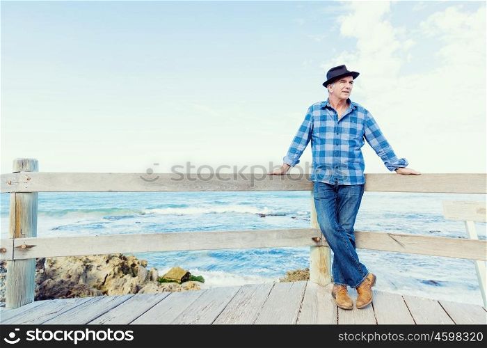 Portrait of an od man next to ocean. Nice morning to meet ocean