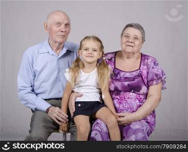 Portrait of an old couple of eighty years old with her granddaughter four years.