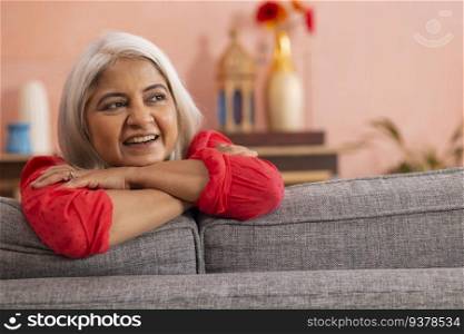 Portrait of an old woman leaning on sofa and looking away