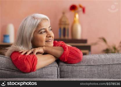 Portrait of an old woman leaning on sofa and looking away