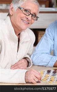 portrait of an old woman playing checkers