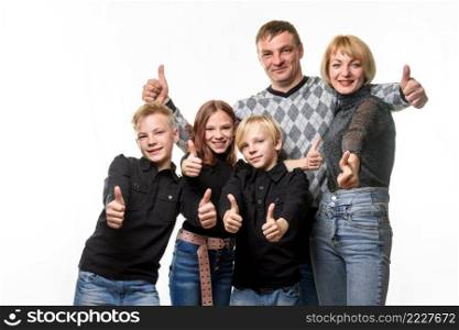 Portrait of an ordinary large family, everyone shows a thumbs up and joyfully looks into the frame a. Portrait of an ordinary large family, everyone shows a thumbs up and joyfully looks into the frame