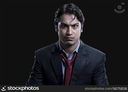 Portrait of angry businessman over black background