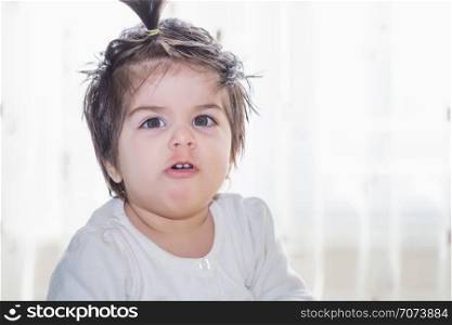 Portrait of angry face of adorable cute little baby girl toddler looking at camera . Portrait of adorable cute little baby girl