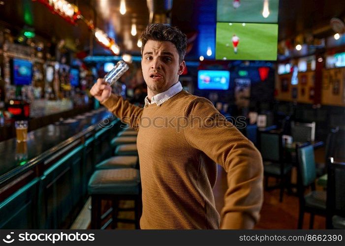 Portrait of angry mad man attacking with empty beer bottle looking at camera. Craze football fan upset about loss of favorite team. Angry man attacking with empty beer bottle