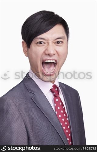 Portrait of angry young businessman, studio shot