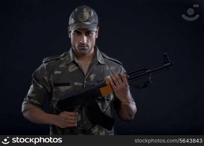 Portrait of angry young military soldier holding gun