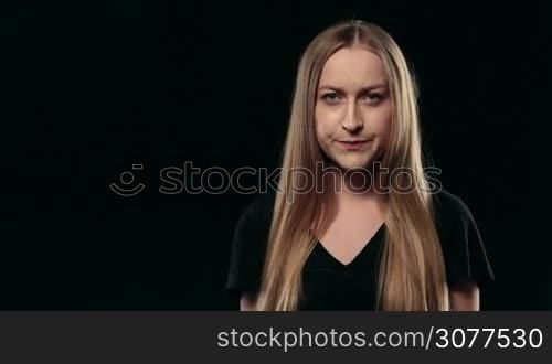 Portrait of annoyed lovely woman shouting with rage and gesturing furiously on black background. Angry blonde female yelling at someone, expressing her negative emotions. Human face expression emotion reaction.