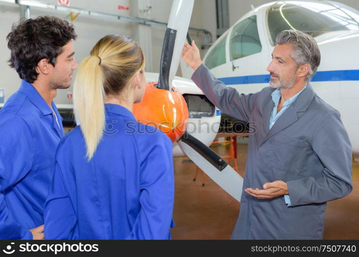 portrait of apprentices and propeller of an airplane