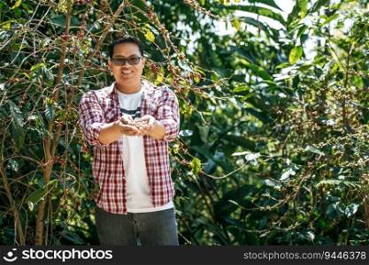 Portrait of Asian agriculturist man showing fresh arabica coffee berries in a coffee plantation. Farmer picking coffee bean in coffee process agriculture.