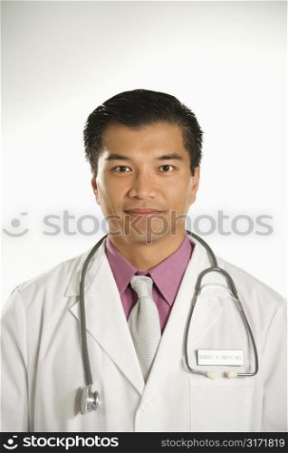 Portrait of Asian American male doctor against white background.