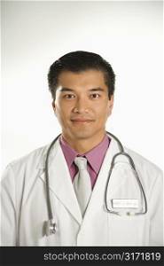 Portrait of Asian American male doctor against white background.