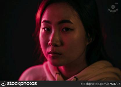 Portrait of asian beautiful girl with long hairstyle on studio background. Young woman in pink and violet neon light. Portrait of asian beautiful girl with long hairstyle on studio background. Young woman in pink and violet neon light.