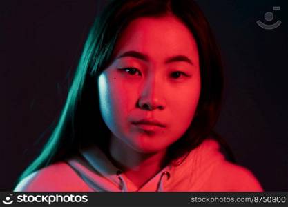 Portrait of asian beautiful girl with long hairstyle on studio background. Young woman in pink and violet neon light. Portrait of asian beautiful girl with long hairstyle on studio background. Young woman in pink and violet neon light.