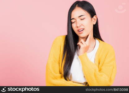 Portrait of Asian beautiful young woman has chin pain, female painful use finger touching itching his chin, studio shot isolated on pink background, Health and medical problem and Dental care concept