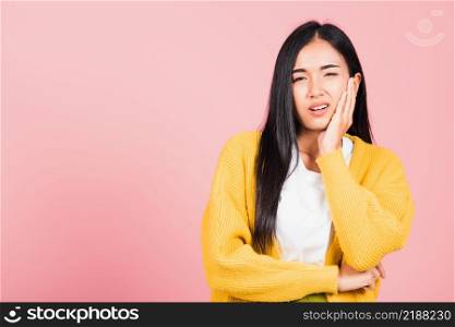 Portrait of Asian beautiful young woman suffering from toothache, female terrible strong teeth pain problem pressing hand to chin, studio shot isolated on pink background, Dental health care concept