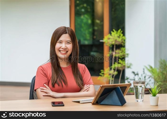 Portrait of Asian business woman using technology tablet for working from home in outdoor home and garden, startups and business owner, covid19 social distance and responsibility or quarantine concept