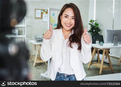 Portrait of Asian Business woman with thumbs up like when recording video for social influence at modern workplace,human resource and small business owner, vlogging and social network concept