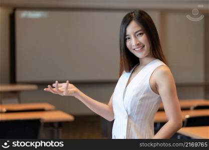 Portrait of asian businesswoman in casual suit standing in gesture or present action in modern office or meeting room or seminar room, Business owner and entrepreneur concept