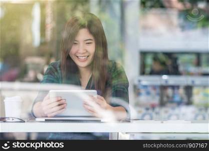 Portrait of asian businesswoman in casual suit using technology laptop for working in happiness action at the desk beside the glass in modern office, Business owner and entrepreneur concept