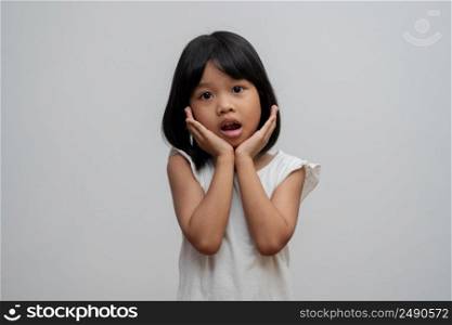 Portrait of Asian child 5 year old and to collect hair and Place her hands on her chin and make thinking pose on isolated white background, She is Happiness, radiance in youth, Education Concept