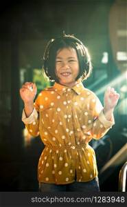 portrait of asian children hearing music in head phone toothy smiling happiness emotion