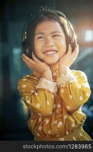 portrait of asian children hearing music in head phone toothy smiling happiness emotion