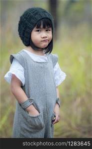 portrait of asian children wearing wool hood standing in green park
