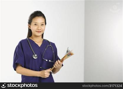 Portrait of Asian Chinese mid-adult female doctor smiling and looking at viewer.