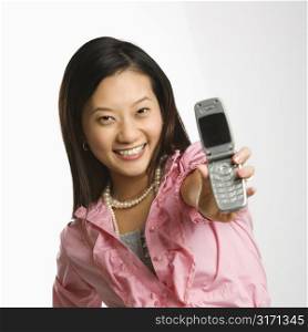 Portrait of Asian Chinese mid-adult female smiling and holding out cell phone towards viewer.