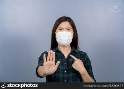 Portrait of asian female wearing face surgical mask and say no action to coronavirus infection on blue color background, covid19 outbreak and pandemic, healthcare and protection against virus concept